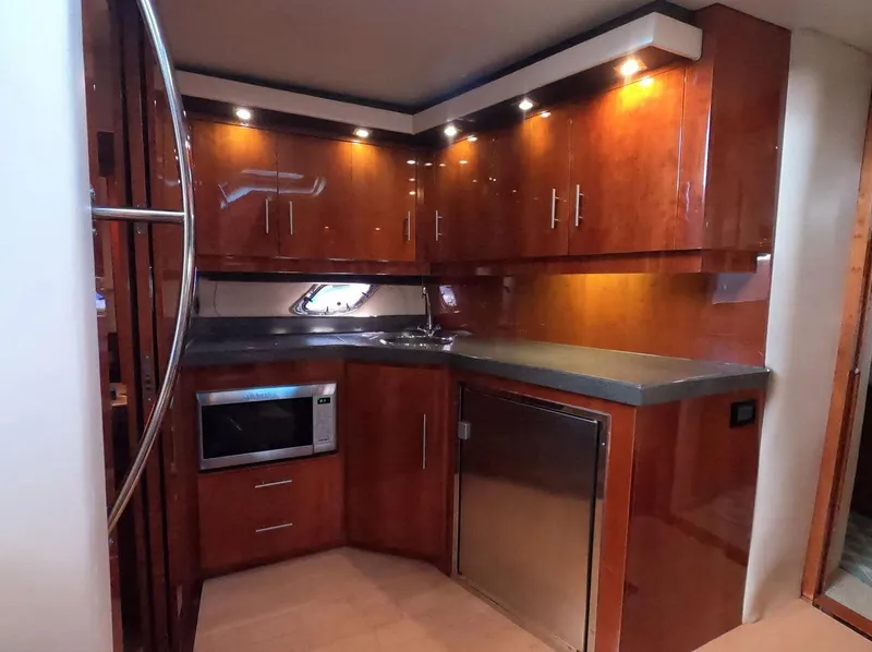 Slide: The Image of Luxurious kitchen in 2011 Regal 42 Sport Coupe yacht with wood cabinets and modern appliances. - 26