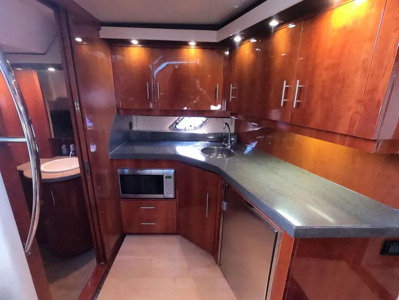 Slide: The Image of Luxurious 2011 Regal 42 Sport Coupe yacht kitchen with wood cabinetry and modern appliances. - 27