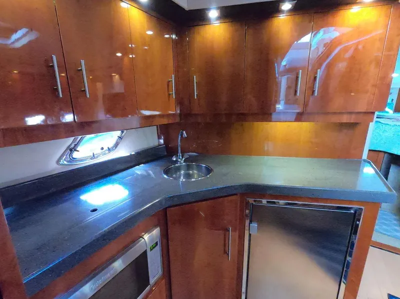 Slide: The Image of Luxurious 2011 Regal 42 Sport Coupe yacht kitchen with sleek wood cabinets and modern appliances. - 28