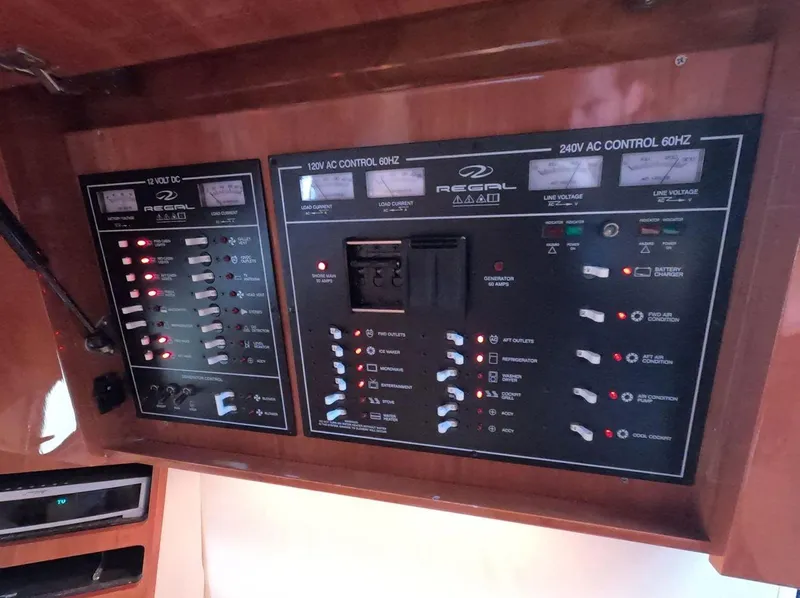 Slide: The Image of Control panel of a 2011 Regal 42 Sport Coupe yacht, featuring AC and DC switches. - 29