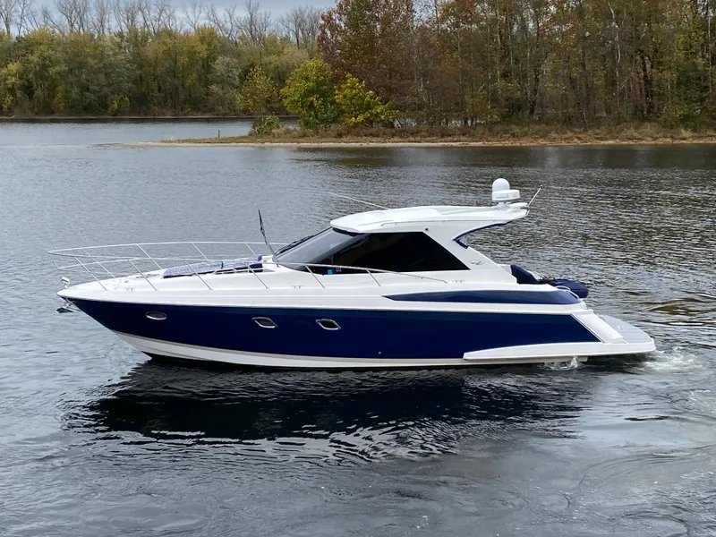 Slide: The Image of 2011 Regal 42 Sport Coupe yacht on a serene lake with autumn trees. - 3