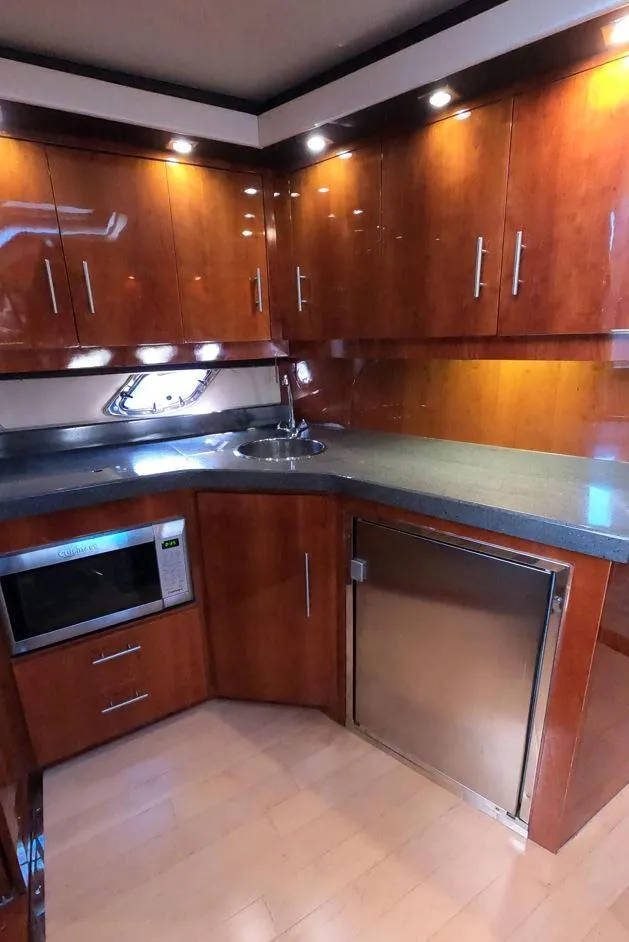 Slide: The Image of Luxurious kitchen in 2011 Regal 42 Sport Coupe yacht with wood cabinets and modern appliances. - 34