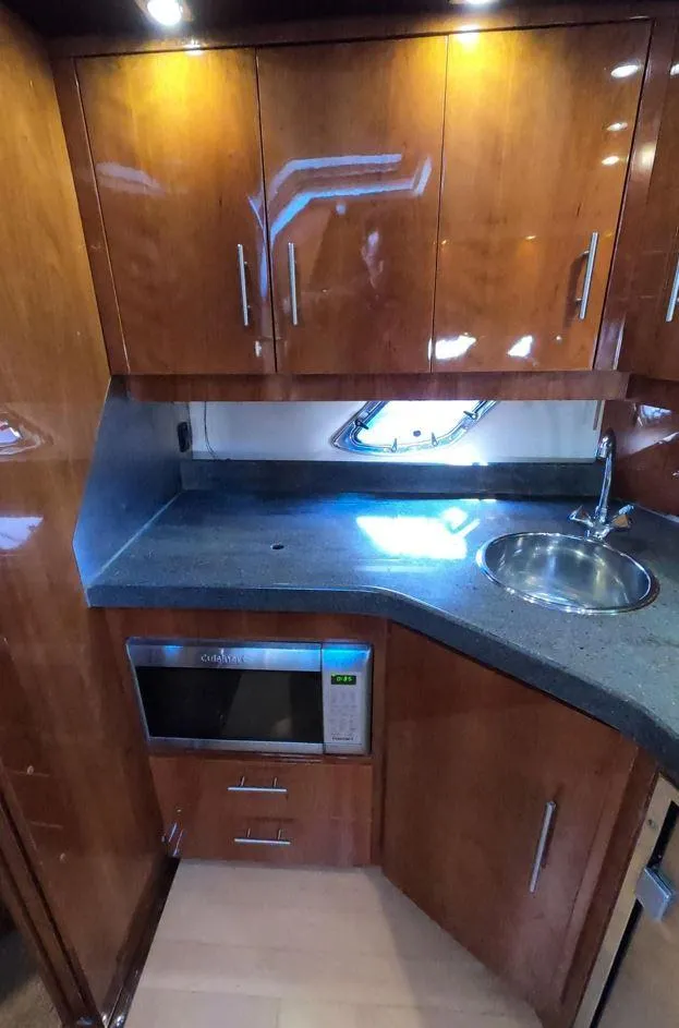 Slide: The Image of 2011 Regal 42 Sport Coupe kitchen with wood cabinets, sink, and microwave. - 35