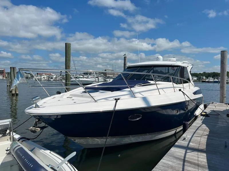 Slide: The Image of 2011 Regal 42 Sport Coupe yacht docked at marina under blue sky. - 4