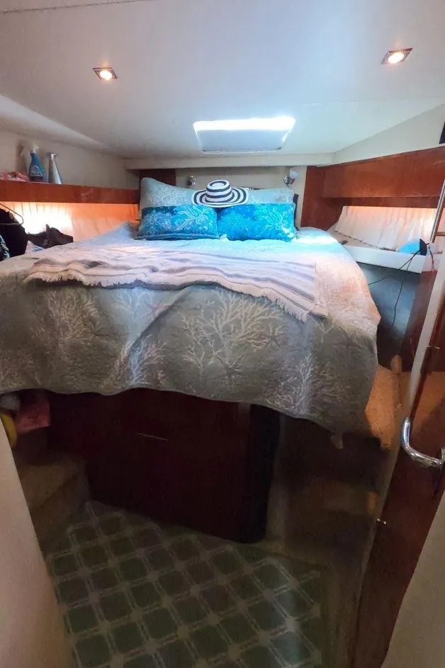 Slide: The Image of Cozy bedroom in 2011 Regal 42 Sport Coupe yacht with plush bedding and ambient lighting. - 41