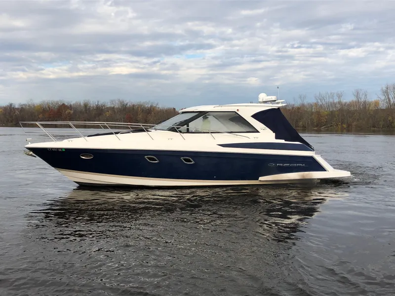 Slide: The Image of 2011 Regal 42 Sport Coupe yacht on calm water under cloudy sky. - 42