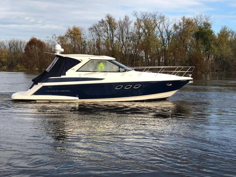 Slide: The Image of 2011 Regal 42 Sport Coupe yacht cruising on a calm river. - 43