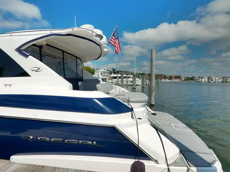 Slide: The Image of 2011 Regal 42 Sport Coupe docked by a marina under a blue sky. - 7