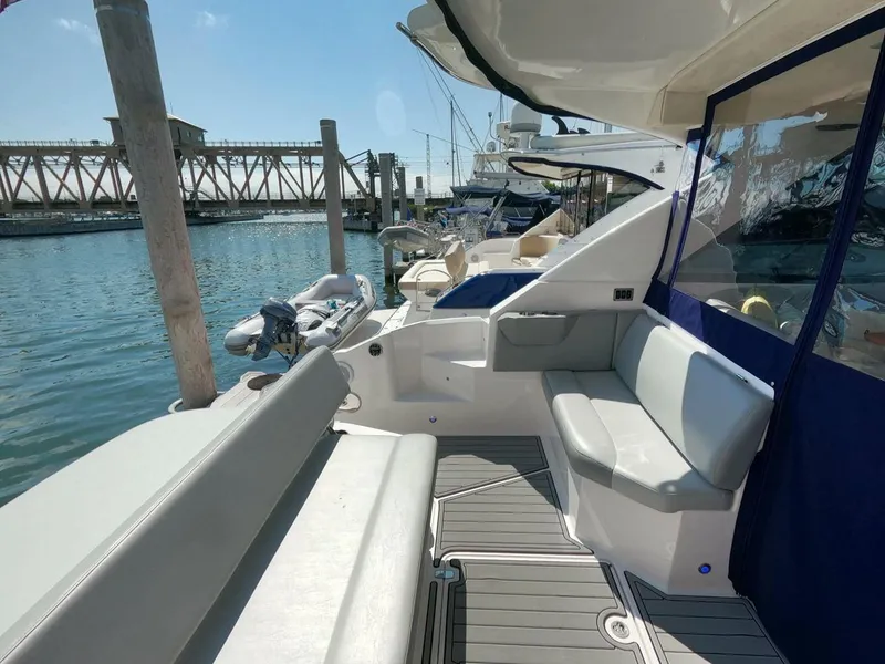 Slide: The Image of 2011 Regal 42 Sport Coupe yacht interior with seating, docked at marina. - 8