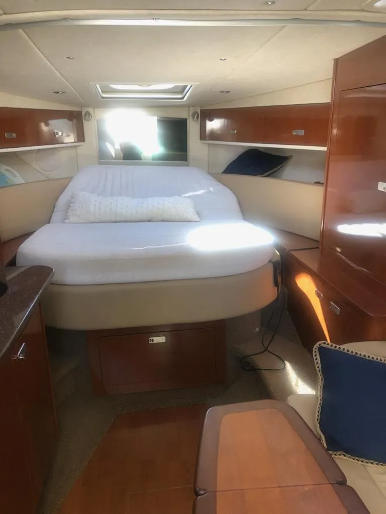Slide: The Image of Interior cabin of 2012 Sea Ray 350 Sundancer with bed and wooden cabinetry. - 5