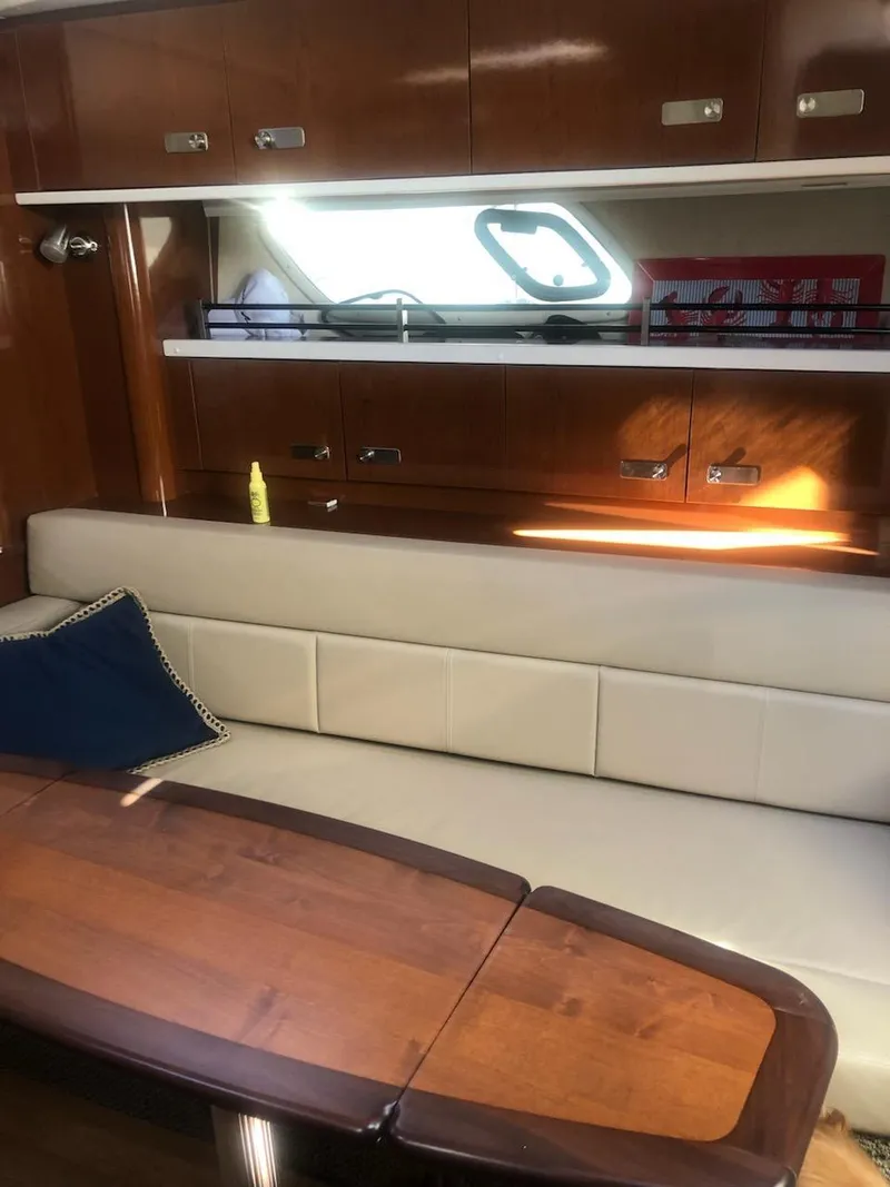 Slide: The Image of Interior of 2012 Sea Ray 350 Sundancer with wooden table and cream seating. - 6
