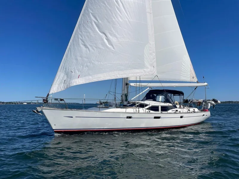 The Image of 2003 Oyster 53 sailboat cruising on open water under clear blue skies. - 0