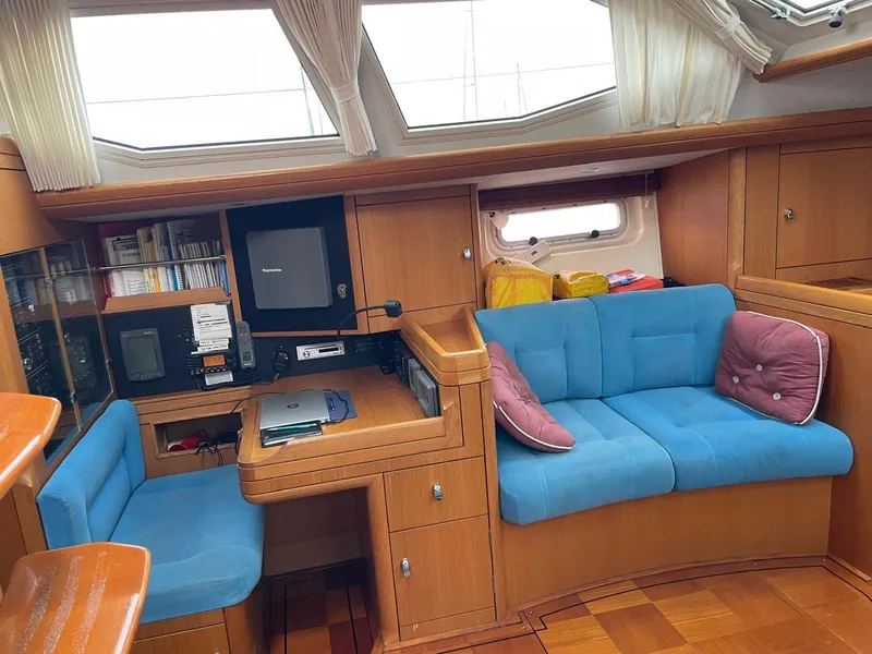 Slide: The Image of Interior of 2003 Oyster 53 yacht with blue seating and wooden cabinetry. - 11