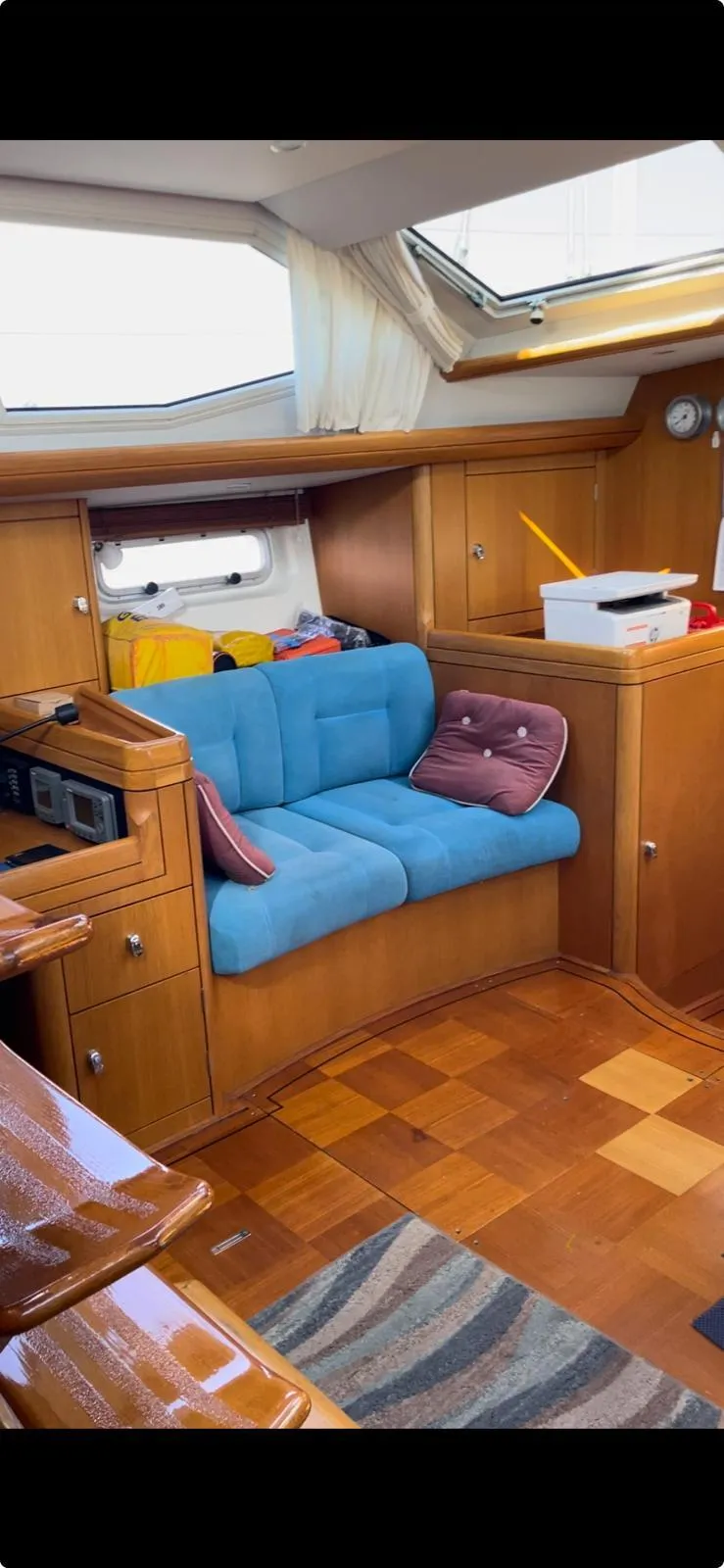 Slide: The Image of Interior of 2003 Oyster 53 yacht with blue seating and wooden cabinetry. - 14