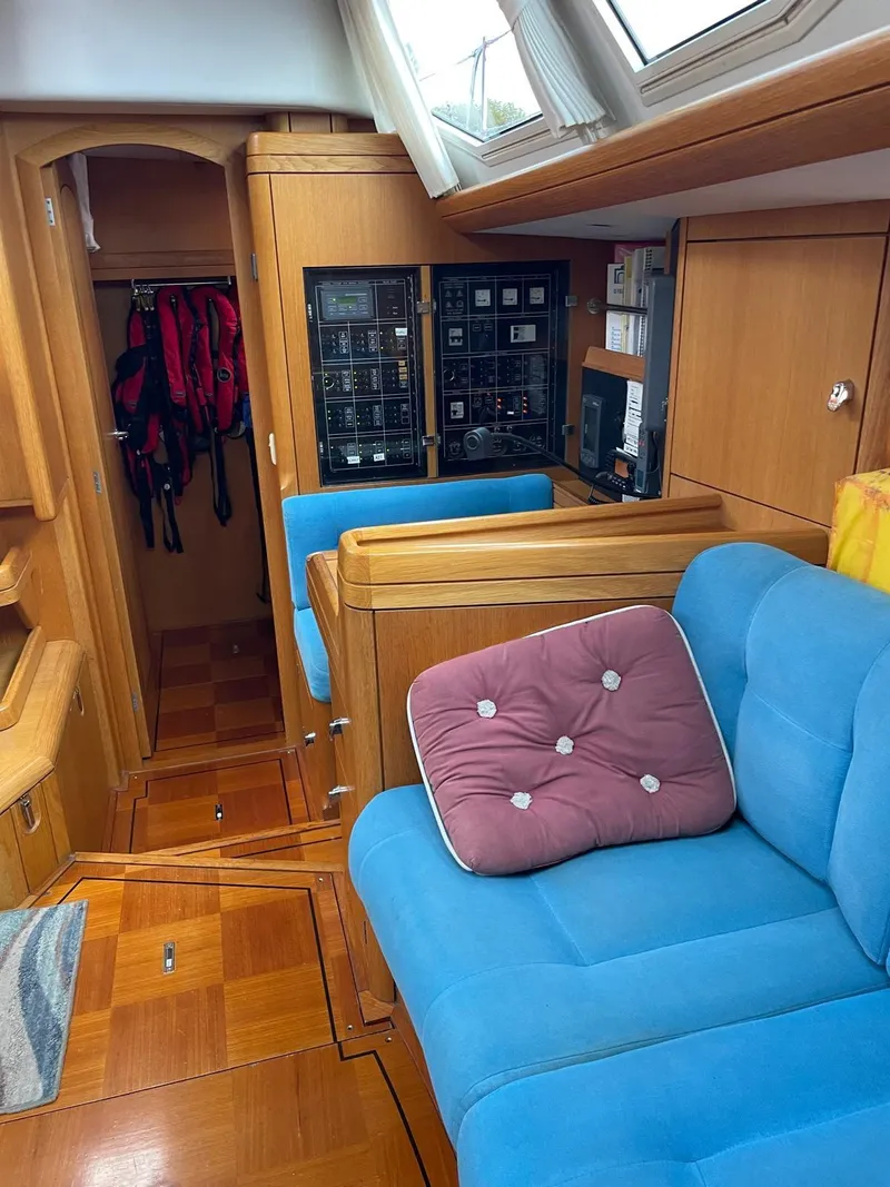 Slide: The Image of Interior of 2003 Oyster 53 yacht with blue seating and wooden cabinetry. - 15