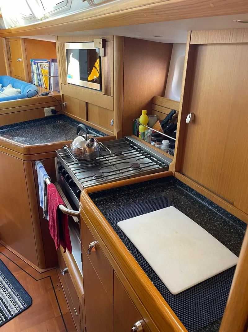Slide: The Image of 2003 Oyster 53 yacht kitchen with wooden cabinetry and modern appliances. - 23