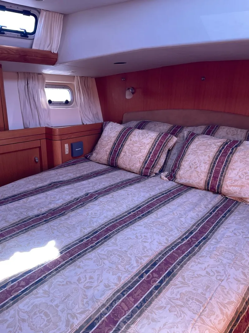 Slide: The Image of Luxurious cabin interior of 2003 Oyster 53 yacht with striped bedding. - 24