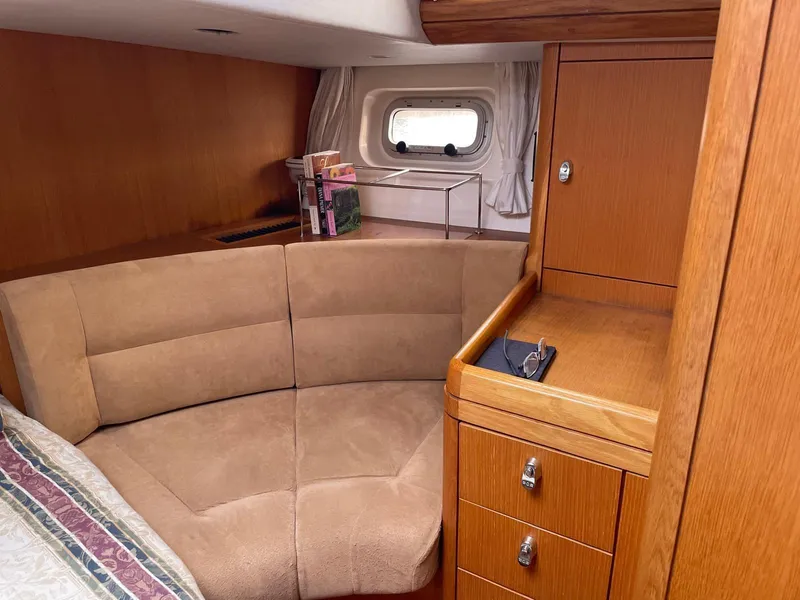 Slide: The Image of Cozy cabin interior of 2003 Oyster 53 yacht with wood finish and seating area. - 26