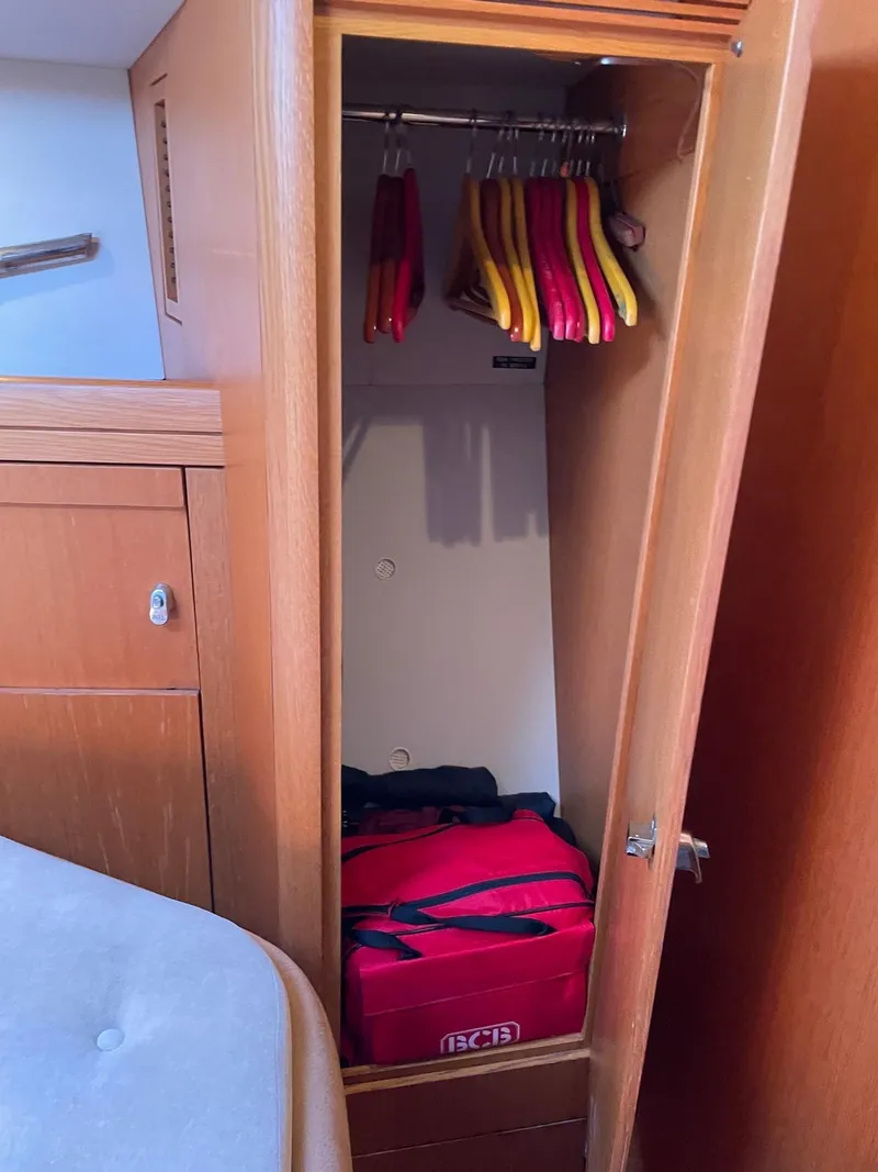 Slide: The Image of Wooden closet in 2003 Oyster 53 yacht with hangers and red bag. - 28