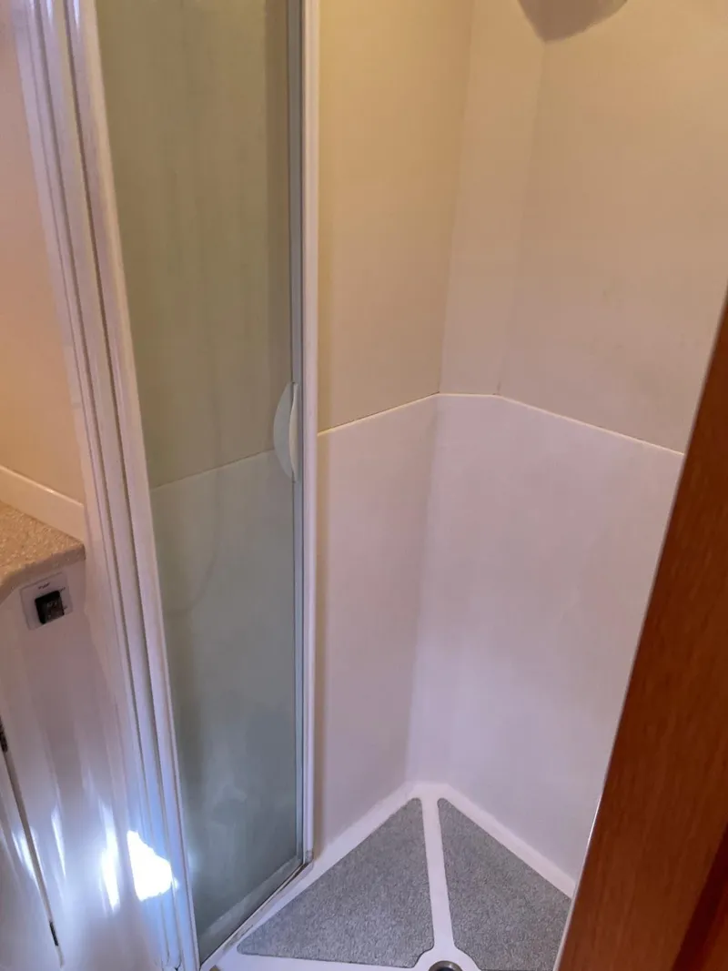 Slide: The Image of Shower area in 2003 Oyster 53 yacht, featuring a compact design and glass door. - 36