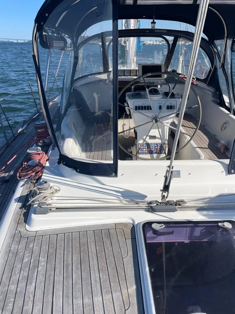 Slide: The Image of 2003 Oyster 53 yacht cockpit with steering wheel and navigation equipment on open water. - 4