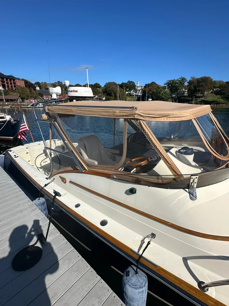 Slide: The Image of Hinckley T29 Express 1997 boat docked, featuring beige canopy and sleek design. - 11