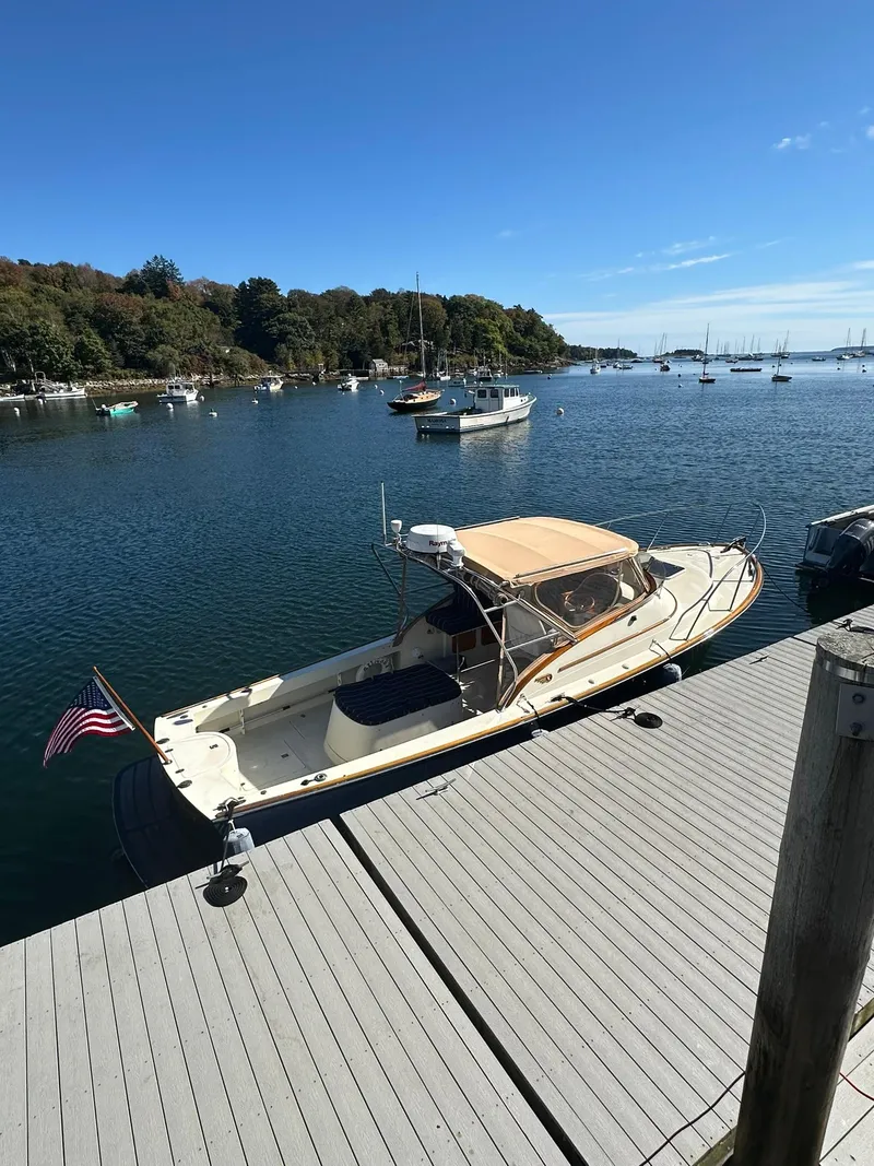 Slide: The Image of 1997 Hinckley T29 Express docked in a serene marina with clear blue skies. - 21
