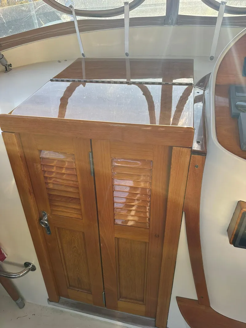 Slide: The Image of Wooden cabinet on 1997 Hinckley T29 Express boat with polished finish and louvered doors. - 23