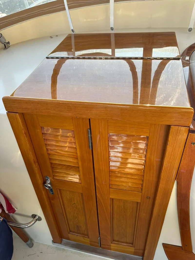 Slide: The Image of Wooden cabinet on 1997 Hinckley T29 Express boat, featuring polished finish and louvered doors. - 29