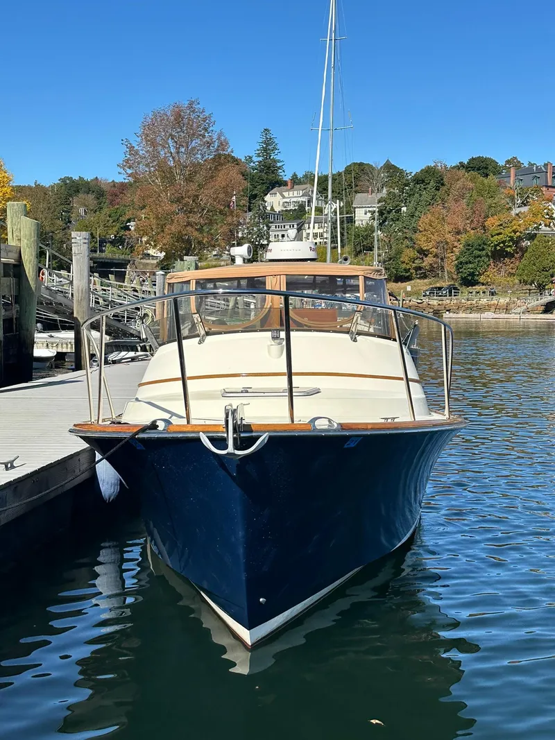 Slide: The Image of 1997 Hinckley T29 Express docked in a scenic marina setting. - 3