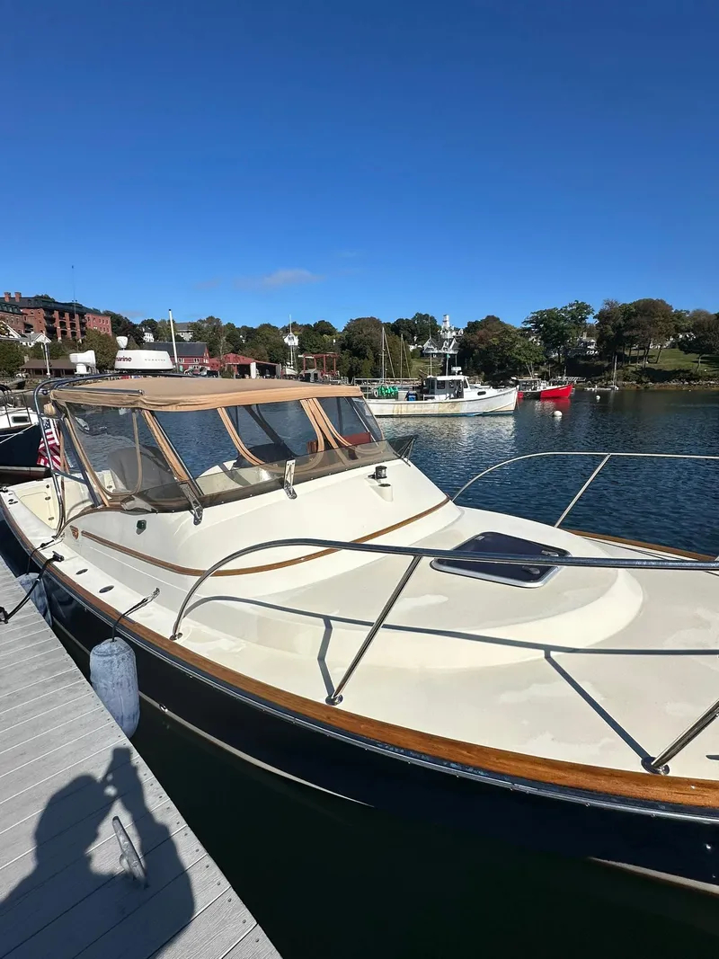 Slide: The Image of 1997 Hinckley T29 Express boat docked in a marina under clear blue skies. - 8