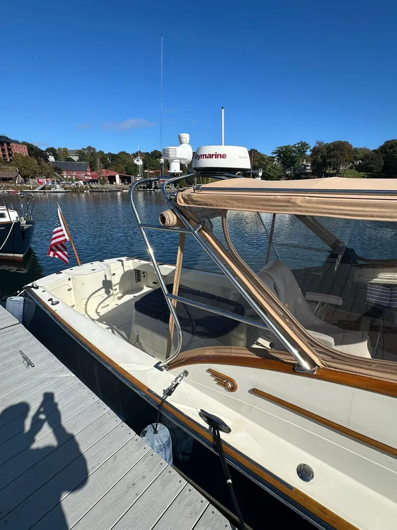 Slide: The Image of Hinckley T29 Express 1997 docked by a scenic waterfront with clear blue skies. - 13