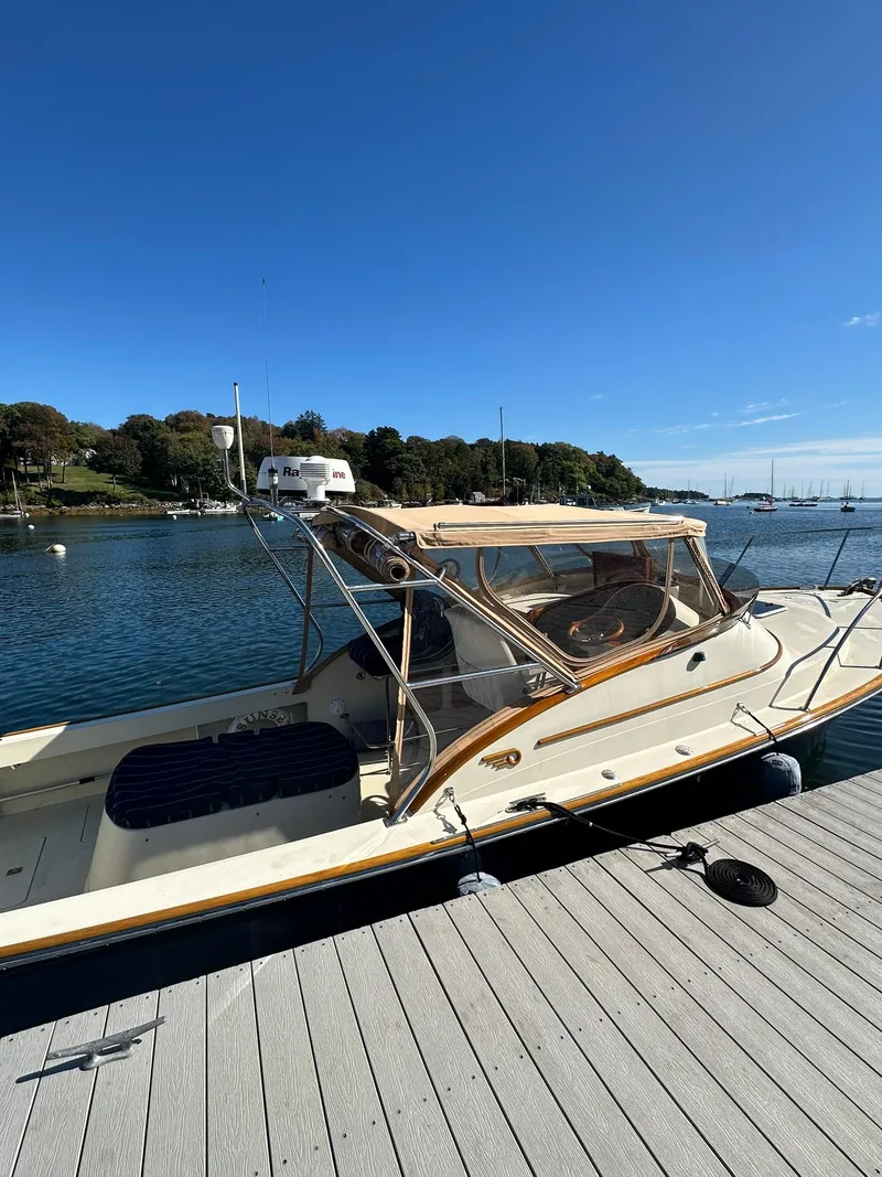 Slide: The Image of 1997 Hinckley T29 Express boat docked by a scenic waterfront. - 18
