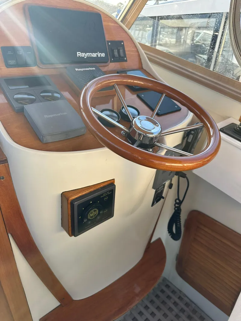 Slide: The Image of Hinckley T29 Express 1997 helm with Raymarine navigation, wooden steering wheel, and control panel. - 25