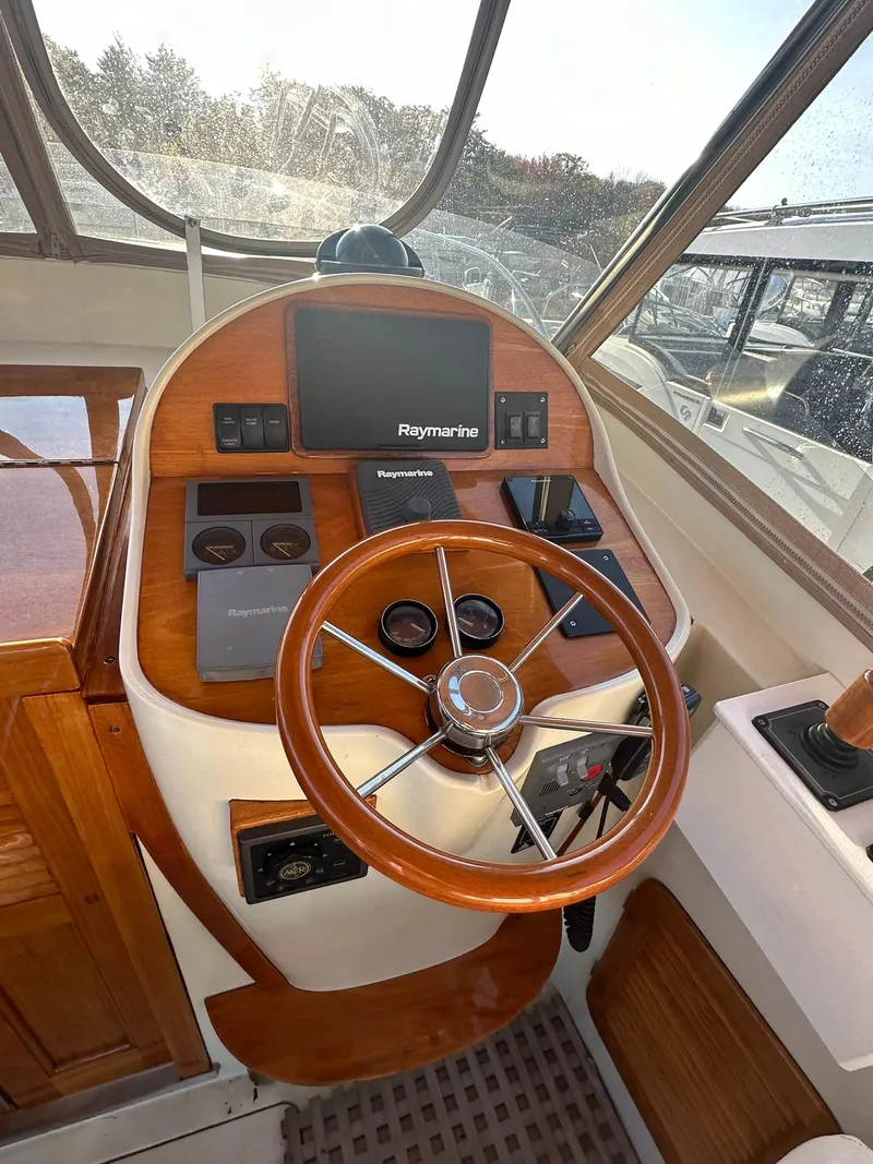 Slide: The Image of 1997 Hinckley T29 Express helm with wooden steering wheel and Raymarine navigation system. - 28