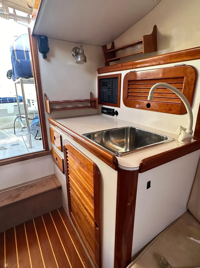 Slide: The Image of 1997 Hinckley T29 Express yacht interior with wooden cabinetry and stainless steel sink. - 32