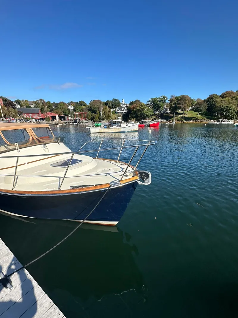 Slide: The Image of Hinckley T29 Express 1997 docked in a serene marina under clear blue skies. - 5