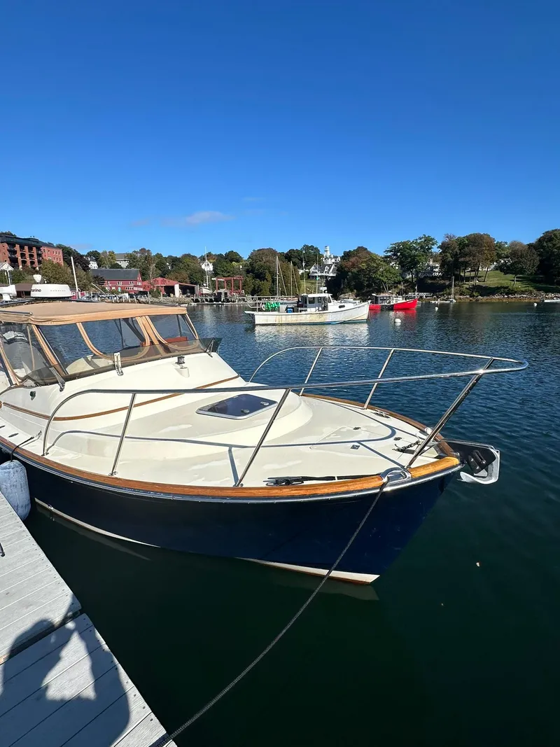 Slide: The Image of Hinckley T29 Express 1997 boat docked in a scenic marina under clear blue skies. - 6