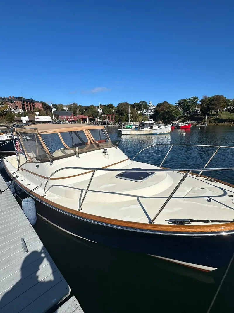 Slide: The Image of 1997 Hinckley T29 Express boat docked in a scenic marina under clear blue skies. - 7