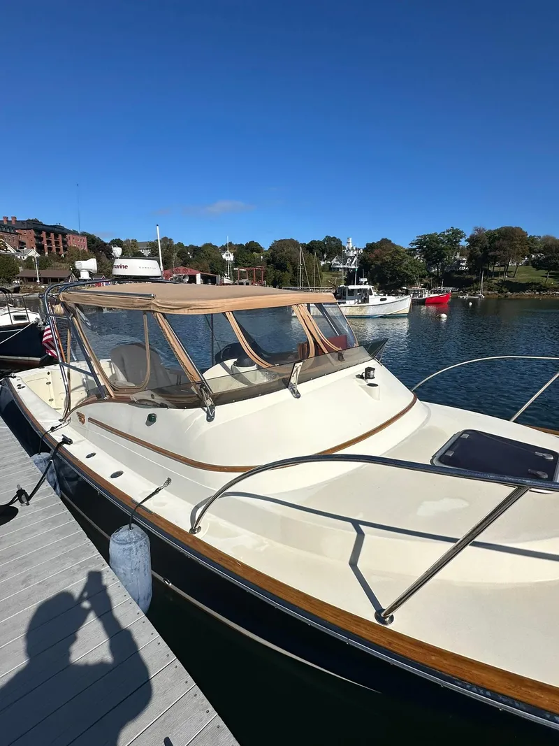 Slide: The Image of 1997 Hinckley T29 Express boat docked in a marina under clear blue skies. - 9