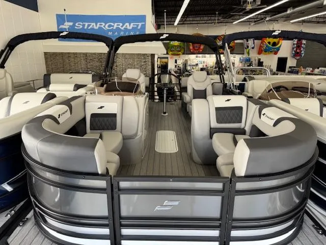 Slide: The Image of 2025 Starcraft SLS 1 pontoon boat in showroom, featuring spacious seating and modern design. - 4