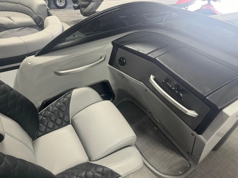 Slide: The Image of 2025 Manitou LX boat interior with sleek black and gray seating. - 10