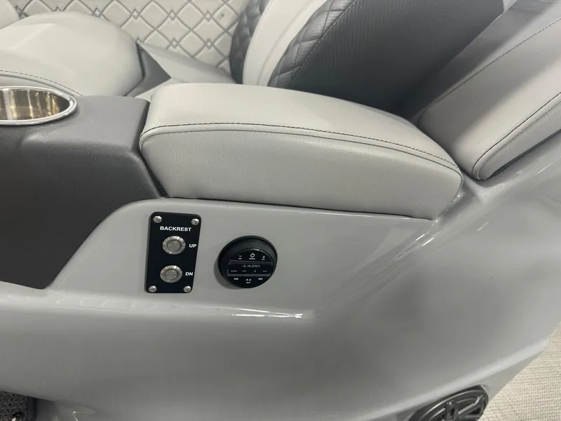 Slide: The Image of 2025 Manitou LX boat interior with gray leather seats and control panel. - 22