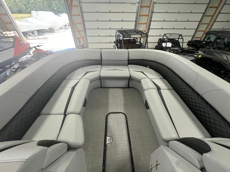 Slide: The Image of 2025 Manitou LX boat interior with spacious seating in a garage setting. - 3