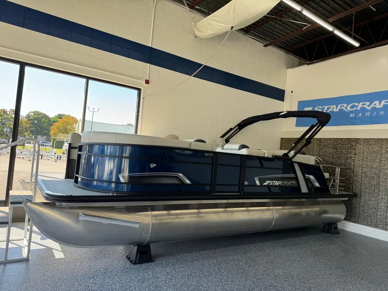 Slide: The Image of 2025 Starcraft EXS 3 Q pontoon boat displayed in showroom. - 0