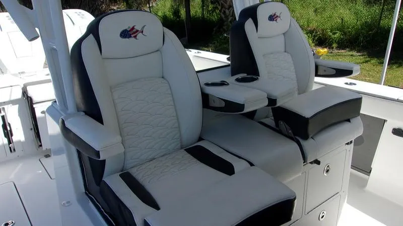 Slide: The Image of 2022 Crevalle 33 CSF Offshore Fishing boat seats, featuring plush white and black upholstery. - 25