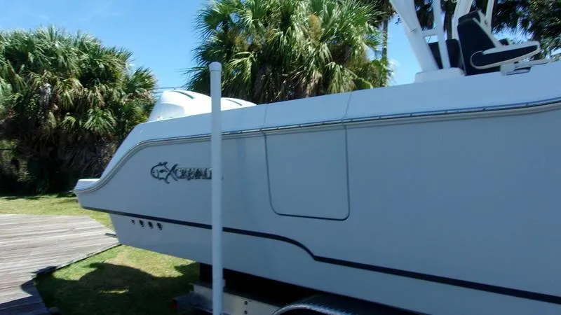 Slide: The Image of 2022 Crevalle 33 CSF Offshore Fishing boat on trailer, surrounded by palm trees. - 7