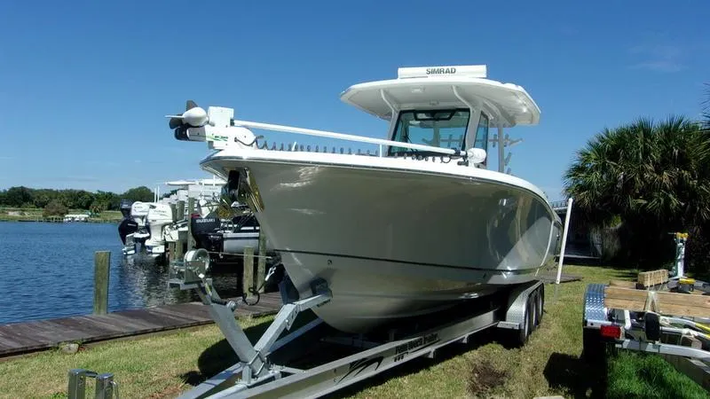 Slide: The Image of 2022 Crevalle 33 CSF Offshore Fishing boat on trailer by the water. - 8