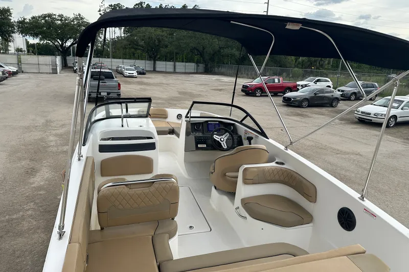 Slide: The Image of 2023 Bayliner VR4 Bowrider OB with tan interior and canopy in parking lot. - 7
