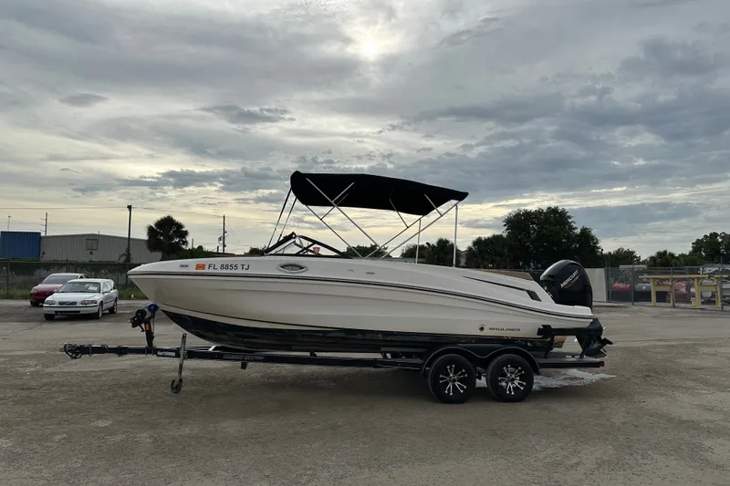 Slide: The Image of 2023 Bayliner VR4 Bowrider OB on trailer, parked outdoors under cloudy sky. - 1